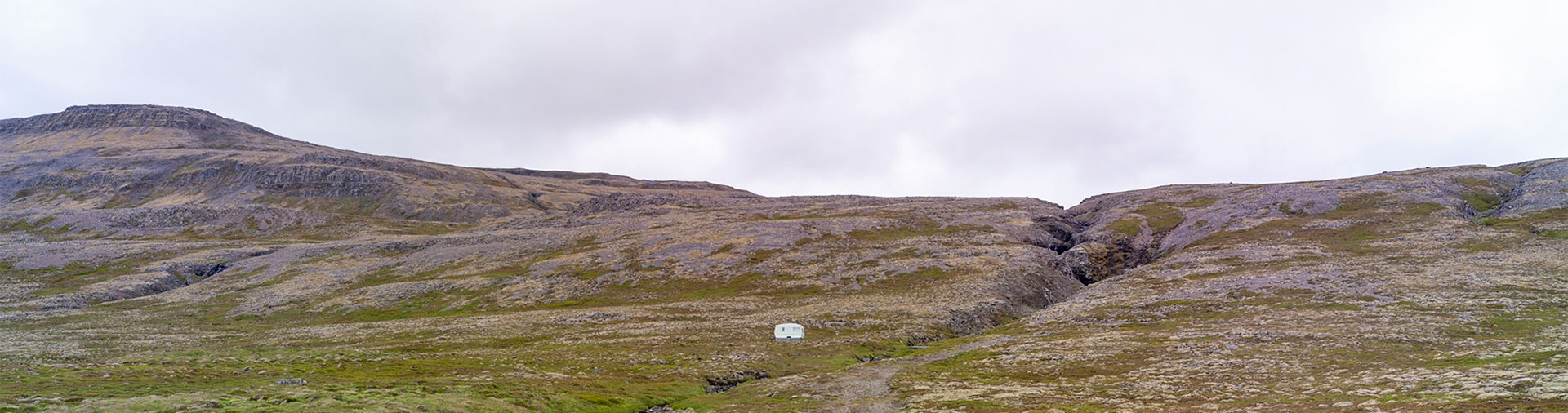 tiny-caravan-amidst-giant-mountain-landscape
