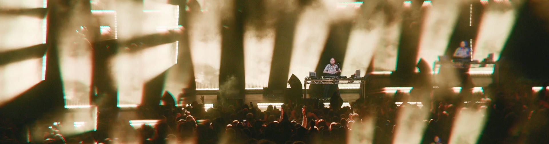 Fatboy Slim performing on stage at his concert with beams of light