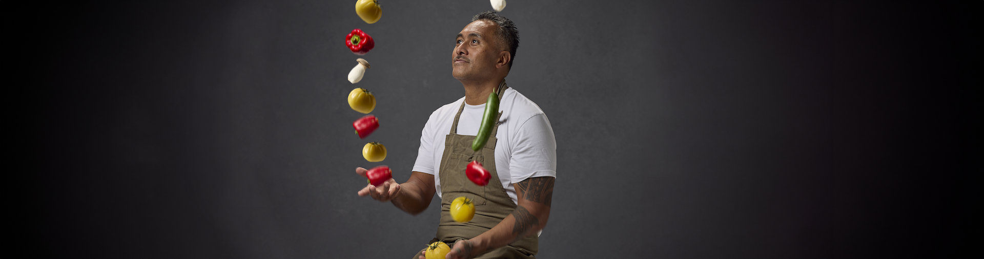 Tony Sokraa juggling vegetables against a dark grey background.