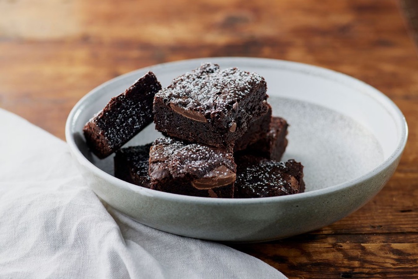 Close up shot of chocolate brownies dusted with icing sugar