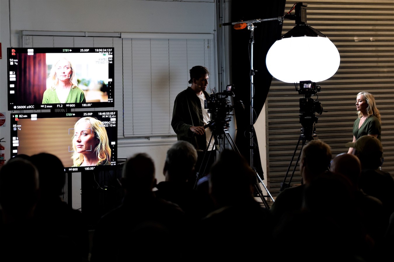 Dave May positioning a camera to capture a model with lantern light illuminating her face