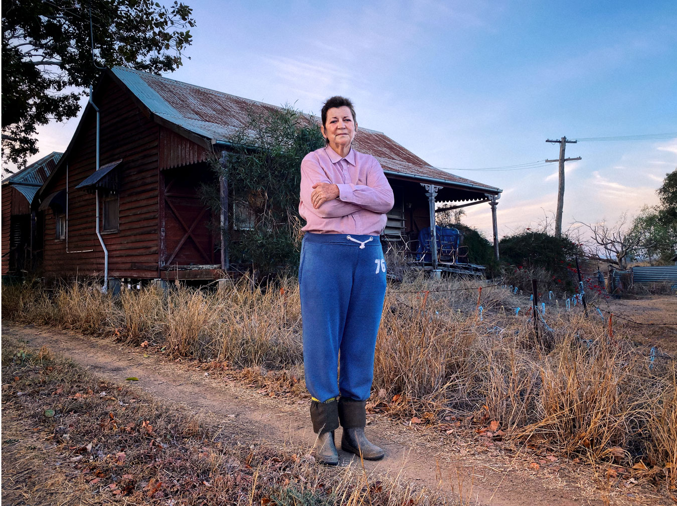 rural-woman-with-house-behind-her