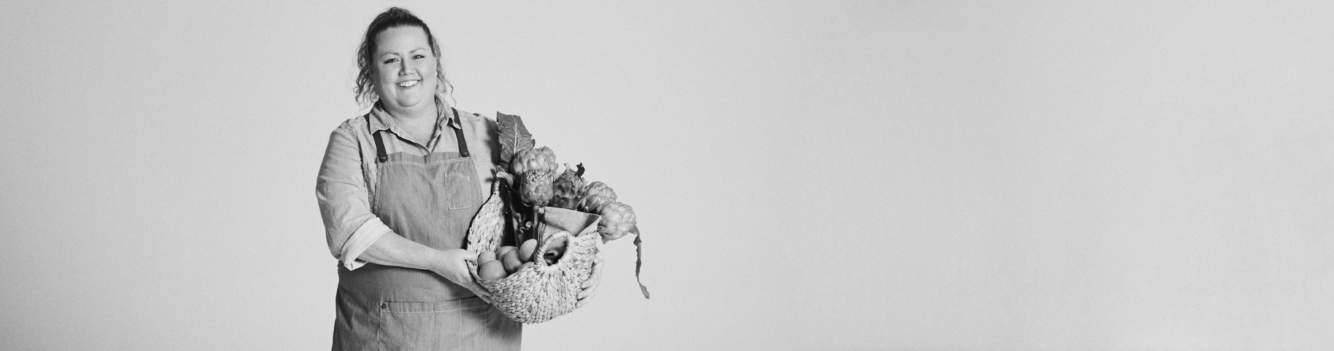 black-and-white-image-of-natalie-jaeger-holding-basket-of-produce-by-kristina-yenko