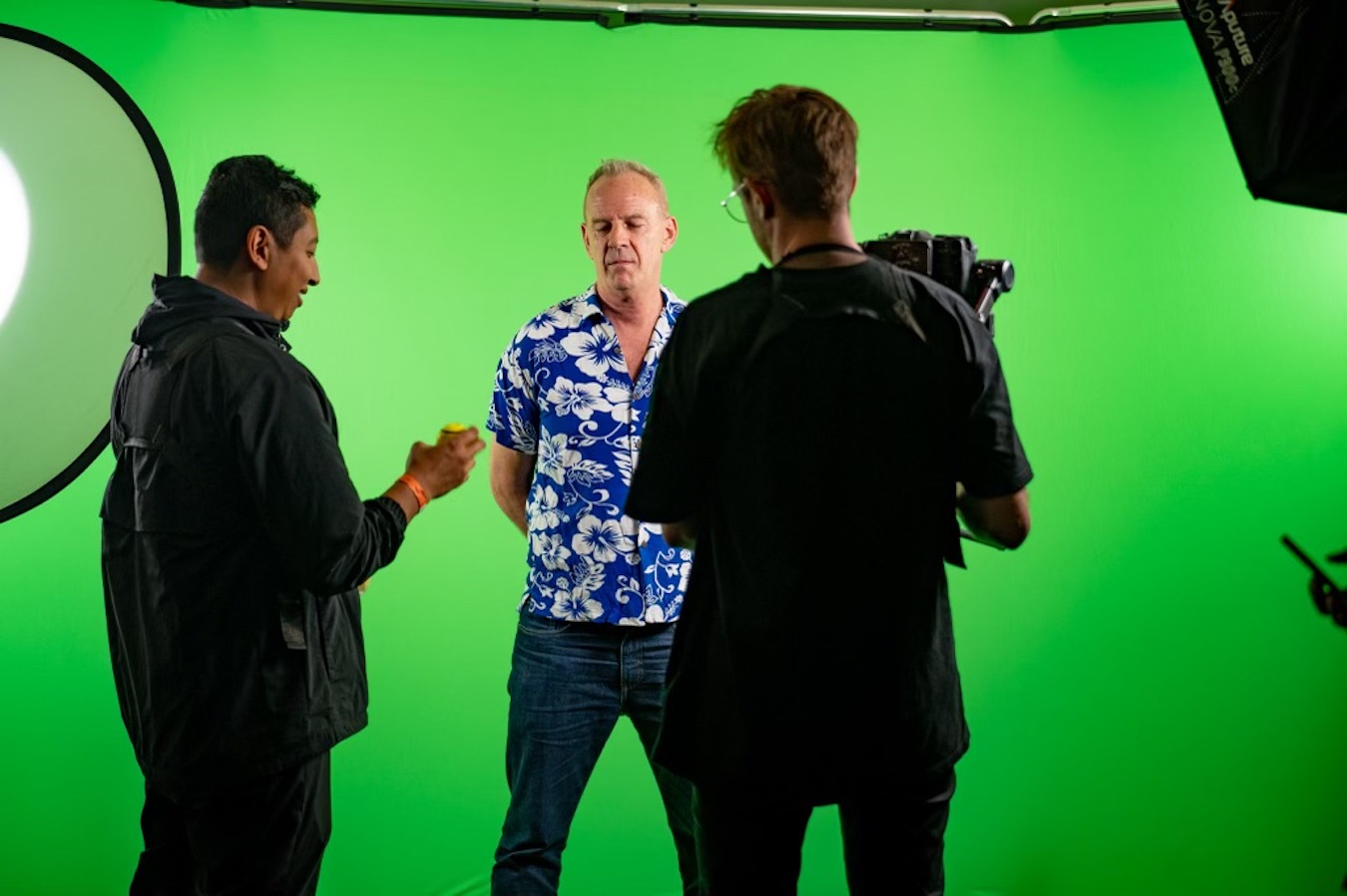 Fatboy Slim standing in front of a green screen with the Mushroom Creative Team