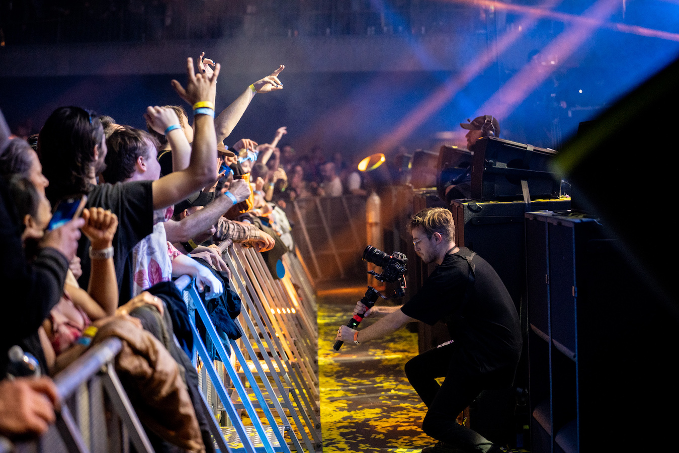 Liam Pethick kneeling down to capture footage of crowds at the concert on the EOS C70