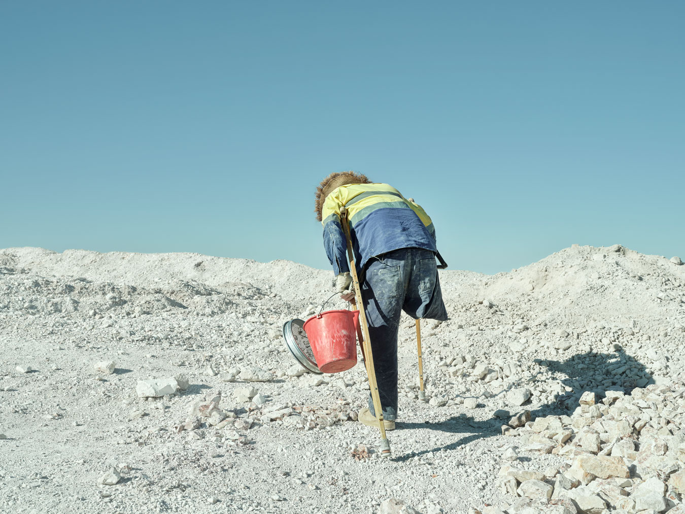 man-from-behind-climbing-dusty-terrain-with-crutches