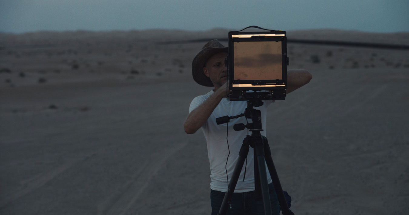 artist-trvor-paglen-in-hat-and-white-shirt-operating-his-camera-at-night