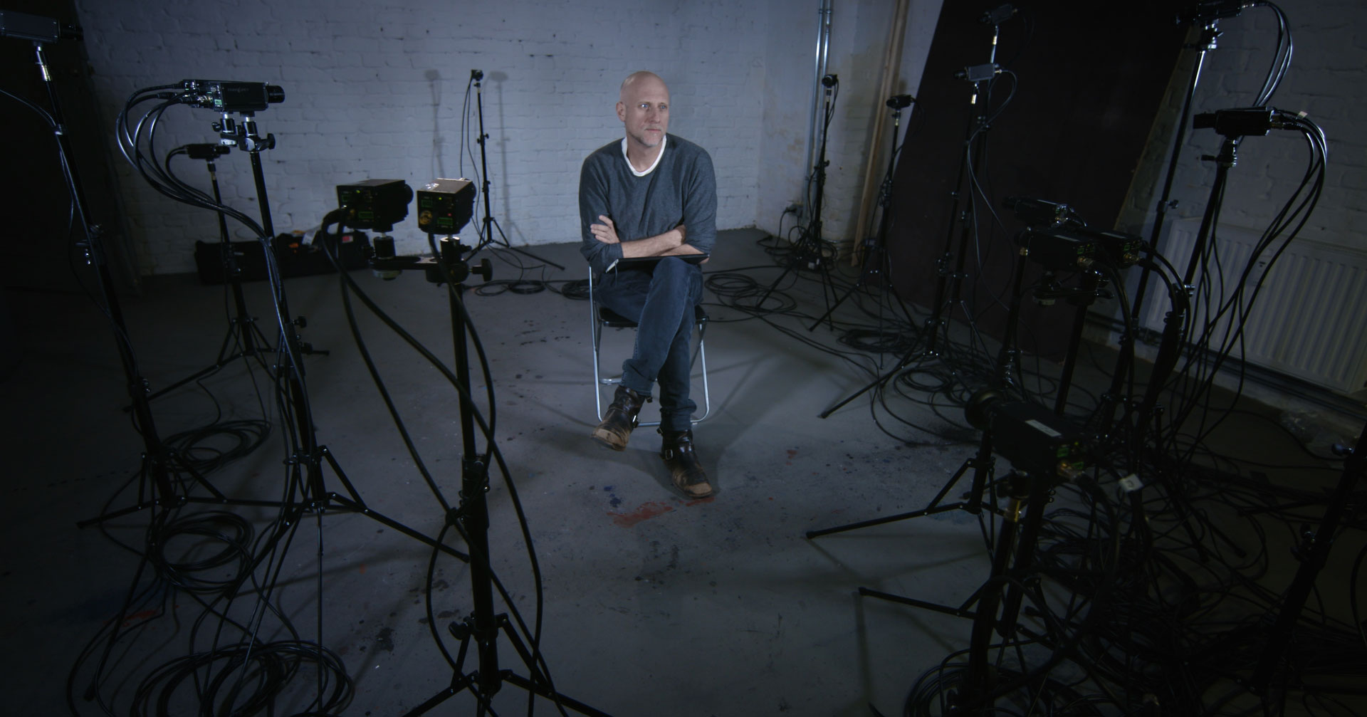 artist-trvor-paglen-in-his-berlin-studio-surrounded-by-cameras-and-technology-arms-crossed