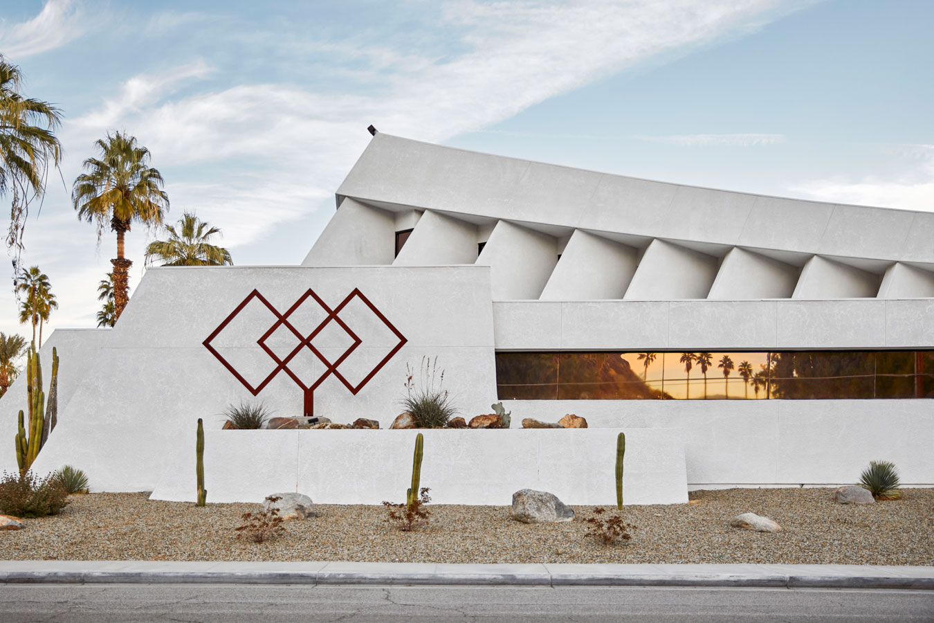 unusual-house-white-with-diamond-patter-admidst-palm-trees-with-palm-trees-reflected-in-windows