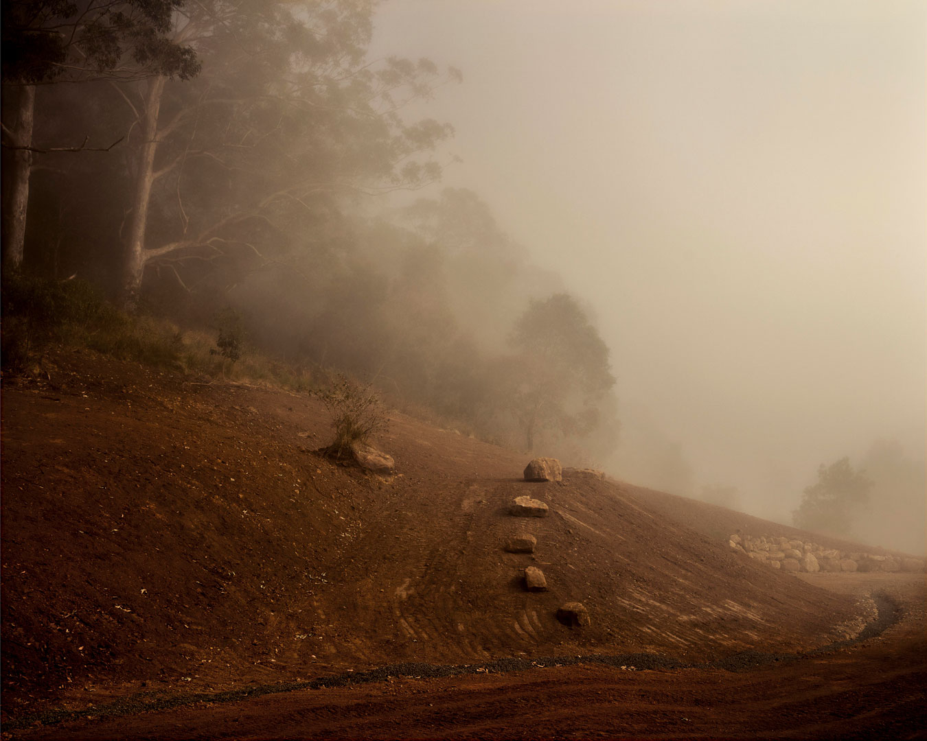 red-dirt-hill-with-rocks-mid-landscaping-in-the-morning-mist