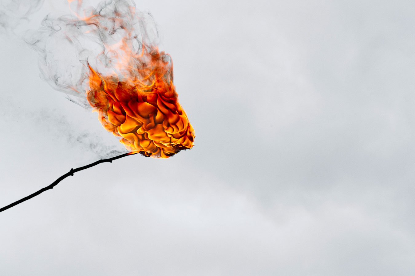 detailed-photograph-of-stick-burning-against-grey-background