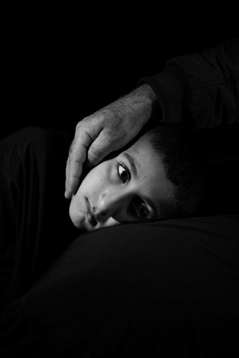 black-and-white-photograph-of-young-boy-with-a-reassuring-hand-over-his-head