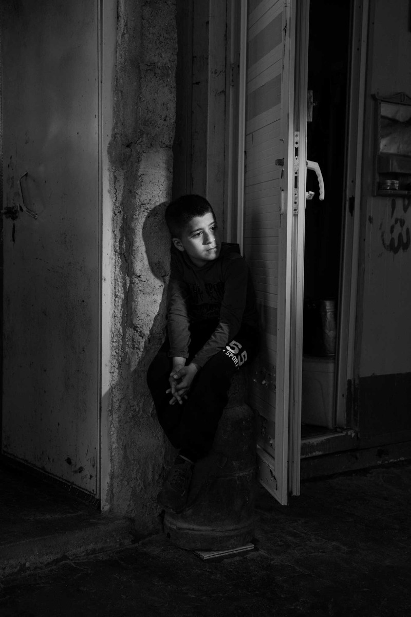 black-and-white-image-of-boy-sitting-on-a-step