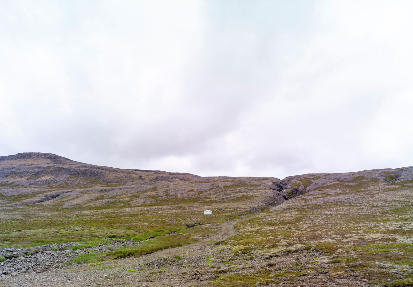 tiny-caravan-lost-amongst-giant-mountain-landscape