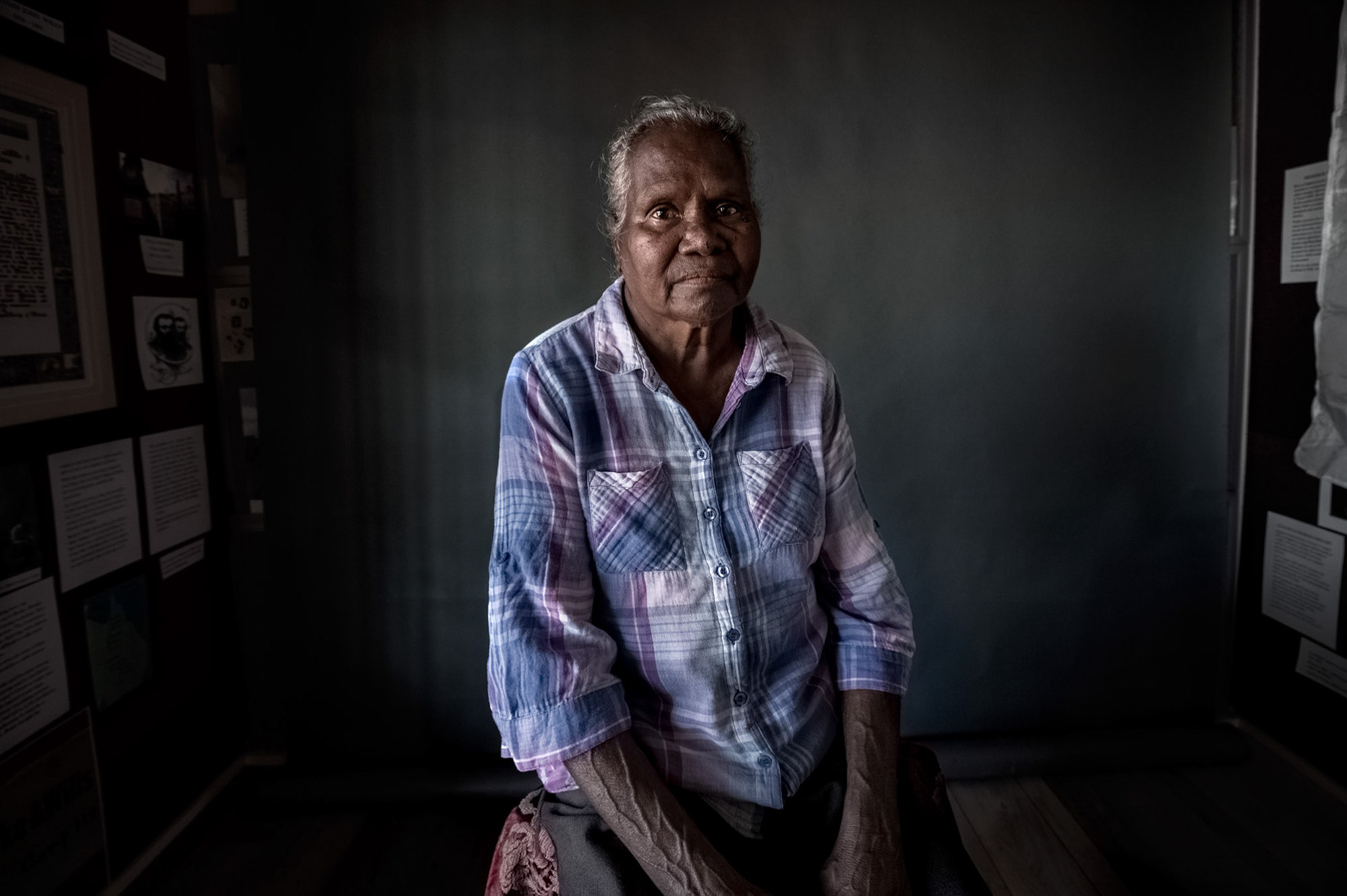 indigenous-australian-woman-in-plaid-shirt-regards-camera