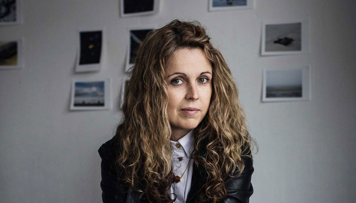 portrait-of-sinead-mcdevitt-with-backdrop-of-photographic-prints