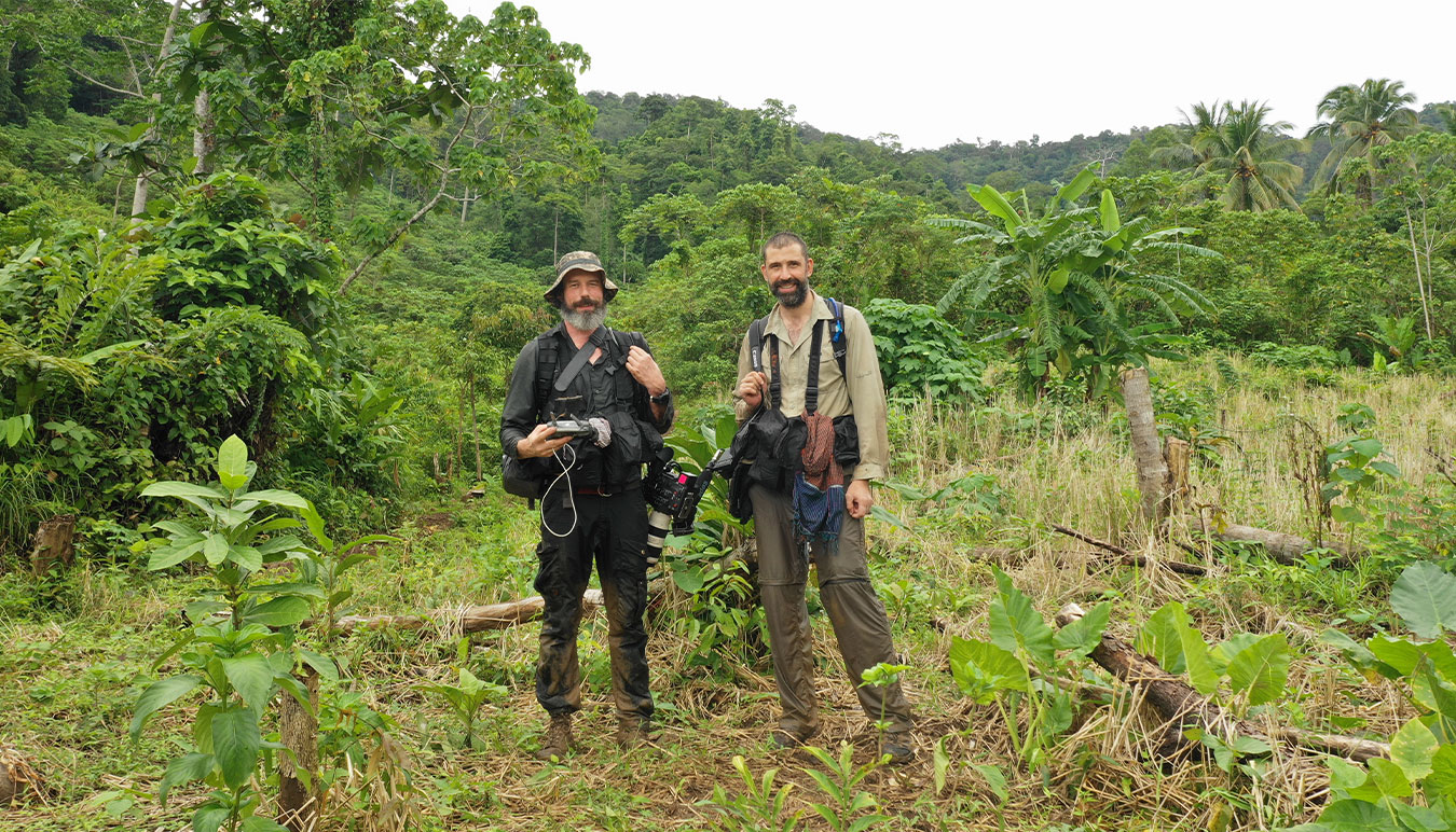 cinematographer-tom-bannigan-with-camera-gear-standing-in-clearing-with-director-karl-malakunas